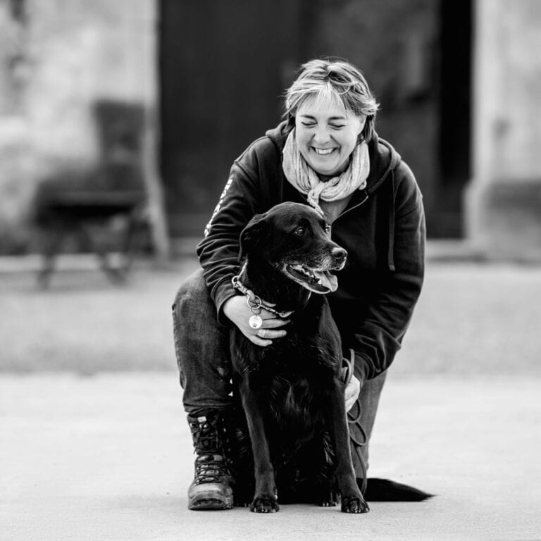 Frau mit Hund im Park, glückliche Hundebesitzerin, Natur, Tierliebe.