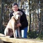 Hundehalterin mit Labrador im Wald, Natur, Spaziergang, Tierliebe, Outdoor-Aktivitäten.